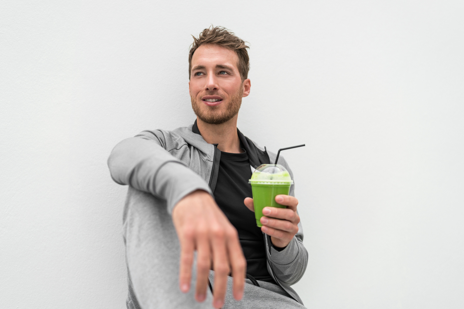 Healthy Man Drinking Green Smoothie Spinach Juice at Home